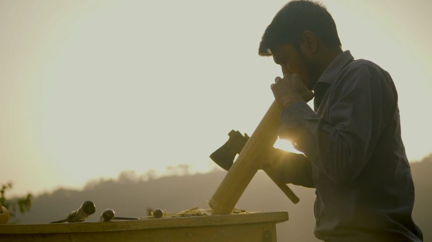 Craftsman carving wood against the sun