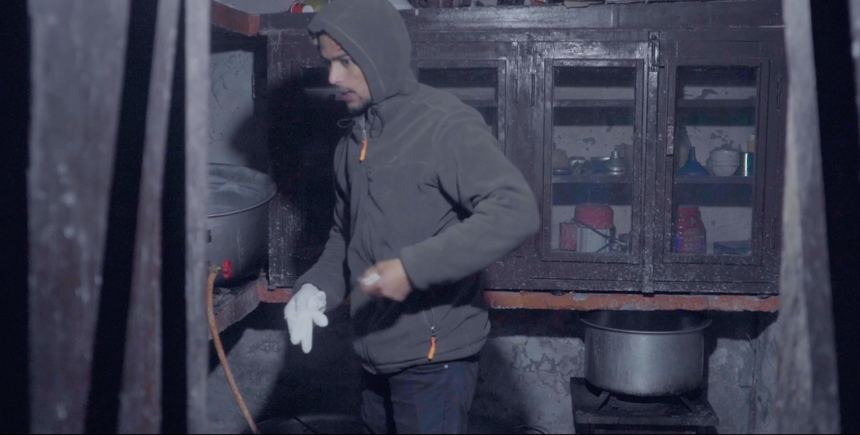 Young man working in a village kitchen